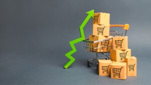 Carrinho de compras com seta apoiada apontando para cima, representando a inflação e seus efeitos.